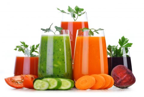 Glasses with fresh vegetable juices isolated on white